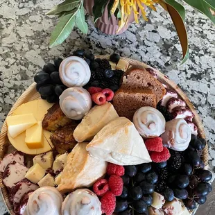Medium brunch board featuring cheeses, fruit and pastries.