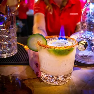 a margarita with a cucumber garnish