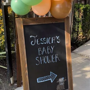 a baby shower sign with balloons