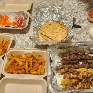 Chicken kabobs, beef kabobs, gyros, pitas, fries, fresh veggies, tzaziki sauce, hummus, baklava. Enough for 4 people!