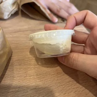 a person holding a container of cream