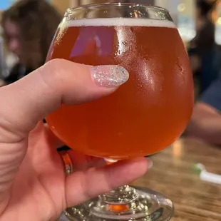 a hand holding a glass of beer