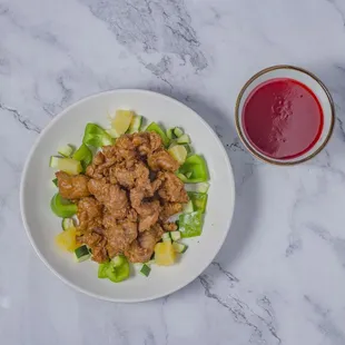 a plate of food and a glass of red liquid