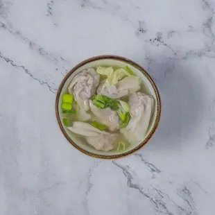 a bowl of soup on a marble table