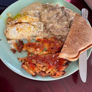Chicken fried steak with eggs, a potato cake, and toast.