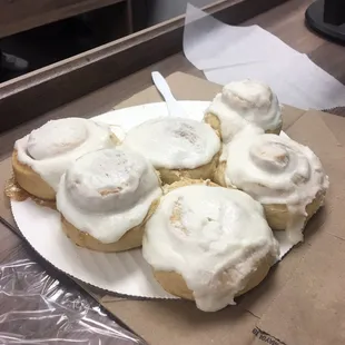 cinnamon rolls with icing on a paper plate