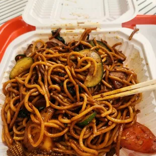 Noodle plate with beef, spinach, cucumber, corn, tomato, and teriyaki sauce.