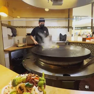 a man cooking in a wok