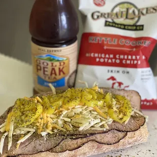a beef steak sandwich with pickles and mustard