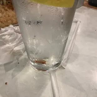 a glass of water with a slice of lemon in it
