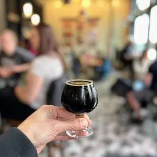 a person holding a glass of beer
