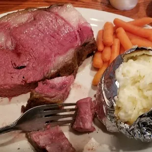 a plate of meat, potatoes and carrots