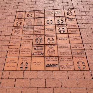 Memorial, advertising, and commemorative blocks in the walkway from the fountain to the station.