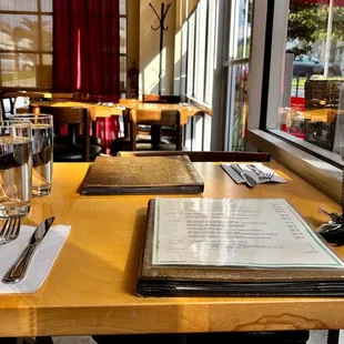 a table with a menu and a glass of water