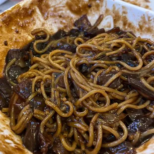 a plate of noodles and meat