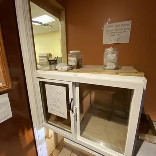 Covid precautions. Door on the left has a spot for payments. Cabinet on the right is the food pass through.