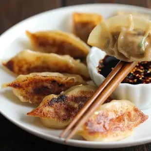 a plate of dumplings and dipping sauce