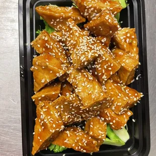 a tray of food with meat and broccoli