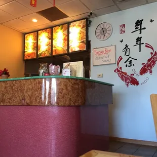 a restaurant counter with asian writing on the wall