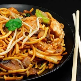 a plate of noodles and chopsticks