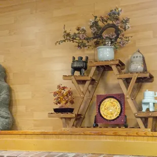a shelf with a buddha statue and a clock
