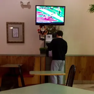 A flat screen television, above a 'condiments' station (packets of soy sauce, duck sauce, salt &amp; pepper, etc).