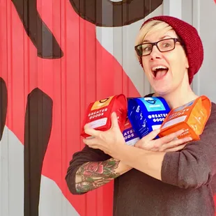 a woman holding two bags of coffee