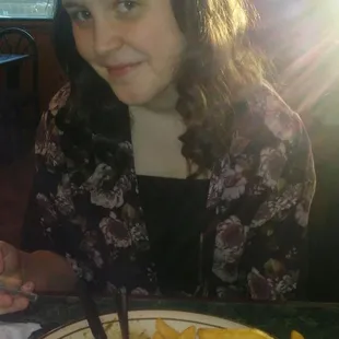 a woman sitting at a table with a plate of food