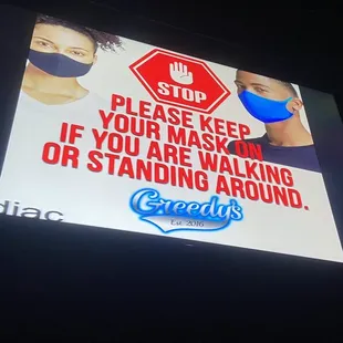 a stop sign and a sign that reads please keep your mask in if you are walking or standing around