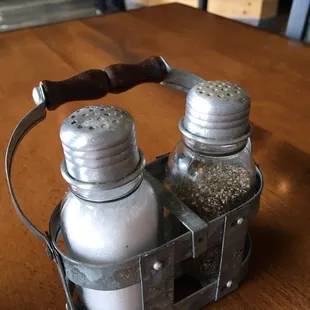 two salt and pepper shakers in a basket