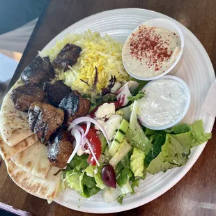 lamb kebab, served with rice , salad, hummus, tzatziki, pita