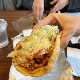 a hand holding a sandwich