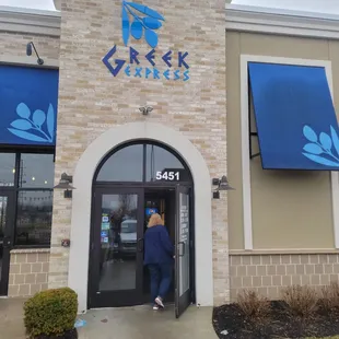 a woman entering a greek restaurant