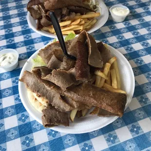 two plates of food on a blue and white checkered tablecloth