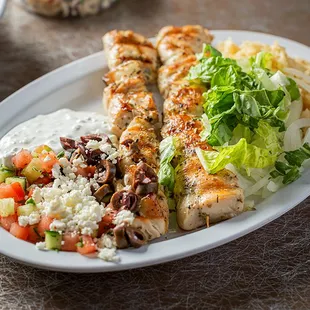 a plate of chicken, salad, and rice