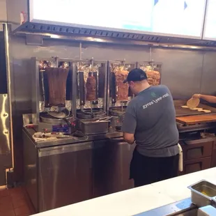 Men cutting meat on a spit. This is the way to eat!