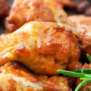 a pile of chicken wings with a sprig of rosemary
