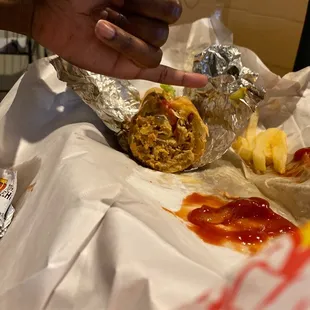 a hand reaching for a burrito
