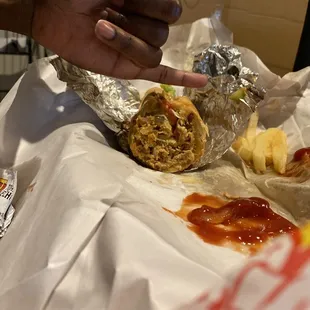 a hand reaching for a burrito