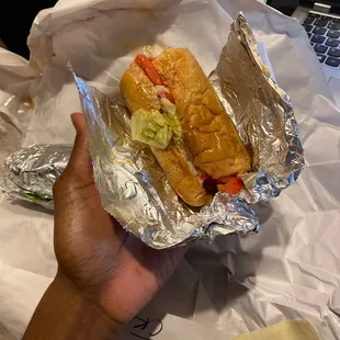a hand holding a sandwich