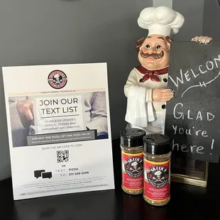 a statue of a chef next to a welcome sign