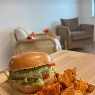 a sandwich and chips on a wooden tray