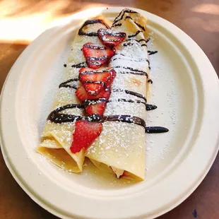 a crepe with strawberries and chocolate sauce