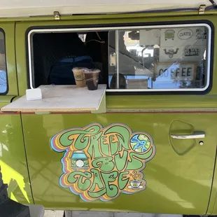 a green van with a coffee cup in the window