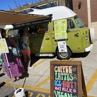 a woman standing in front of a green van