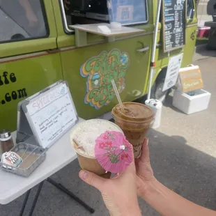 a person holding a cup of coffee and a donut