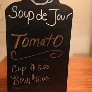 a blackboard with a sign that says soup de jour tomato