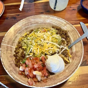 Naked burrito bowl with ground beef, refried beans, and mild verde.