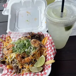 Loaded fries with shrimp, guacamole cilantro and some delicious sauce also an agua Fresca lime cucumber