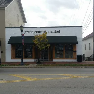 a green truck parked in front of a store